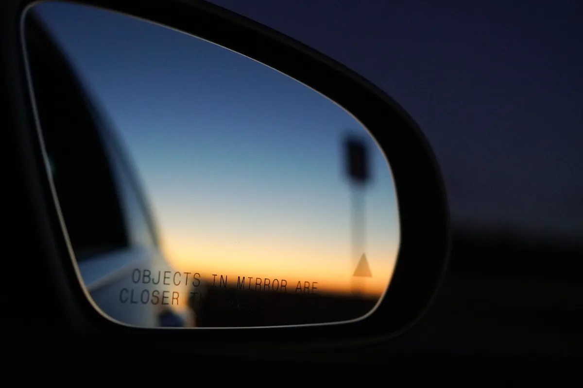 A sunset reflected in a car's wing mirror