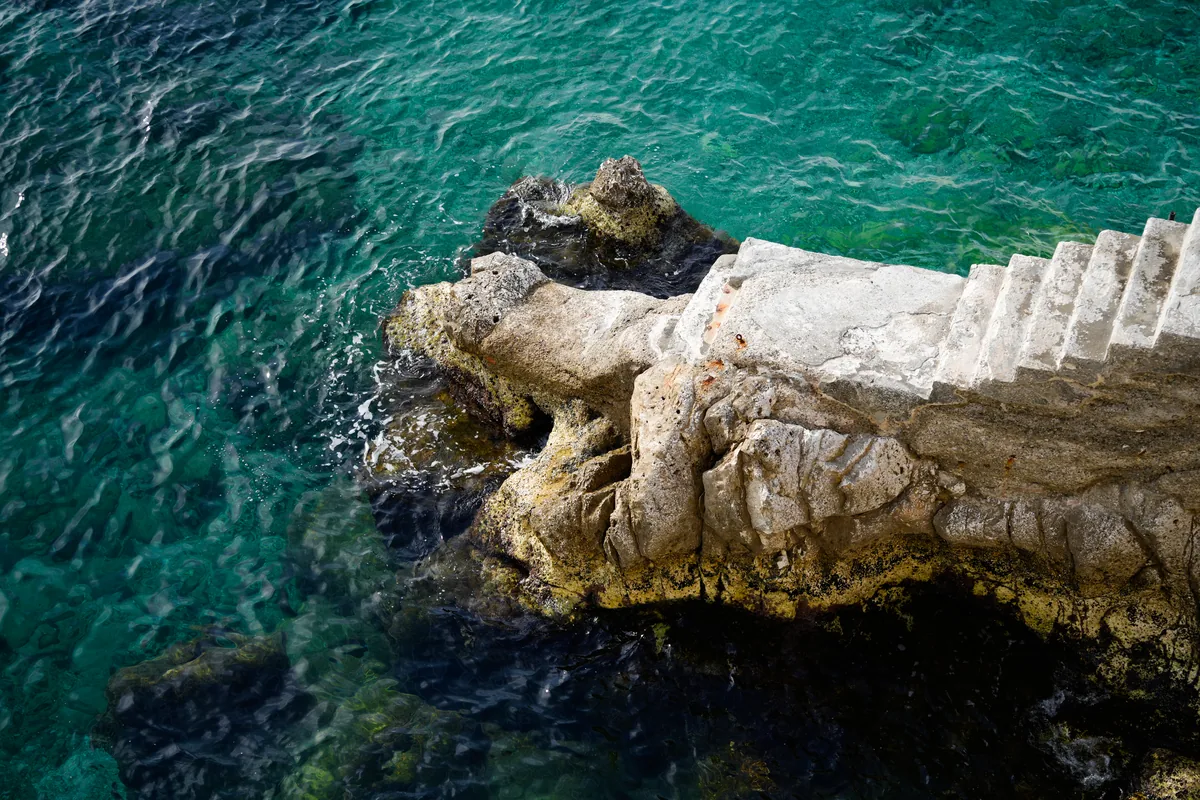 White stone steps leading into clear turquoise water
